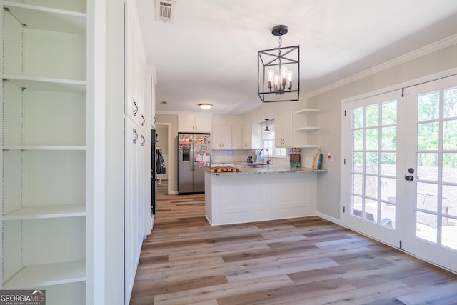 kitchen with a sink, stainless steel fridge, visible vents, crown molding, and open shelves