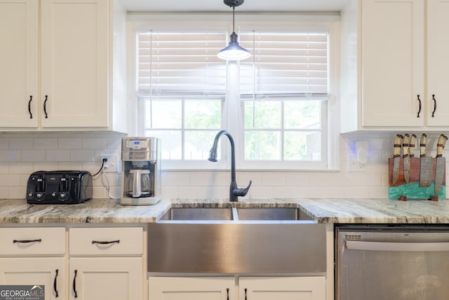 kitchen with decorative backsplash, stainless steel dishwasher, white cabinetry, and a sink