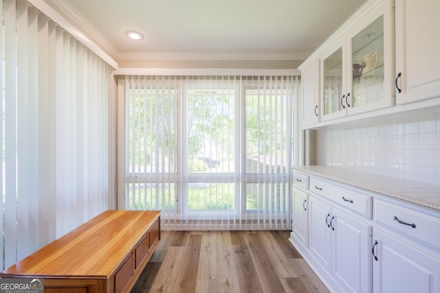 interior space featuring light wood-type flooring and ornamental molding