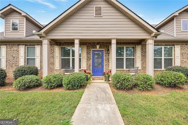 1129 Abundance Dr, Locust Grove, GA 30248 - view of front of home with covered porch, a front lawn, and brick siding