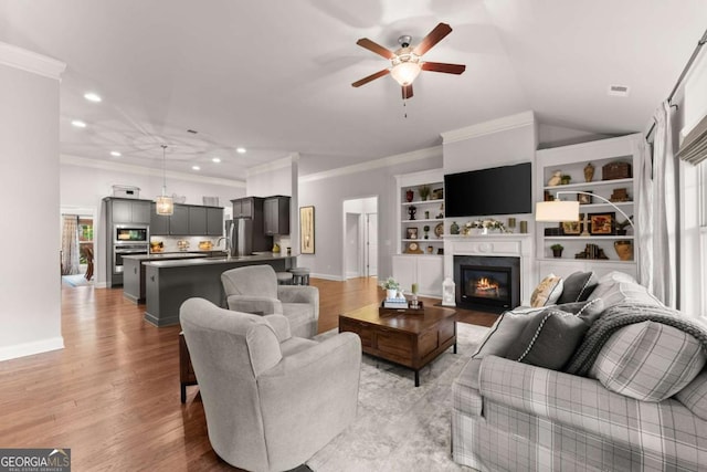 4815 Amble Trce, Cumming, GA 30040 - living area with ornamental molding, ceiling fan, baseboards, recessed lighting, and light wood-style flooring