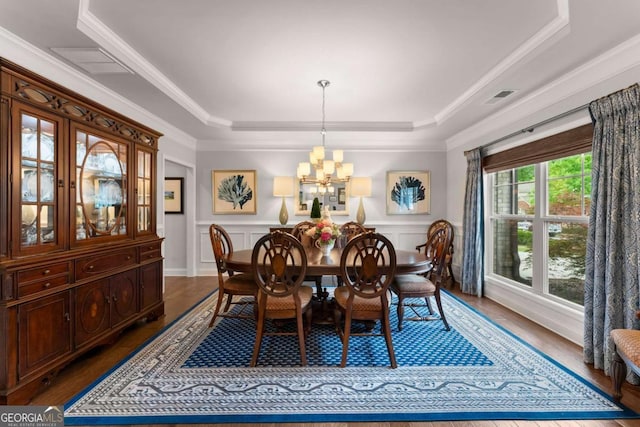 4815 Amble Trce, Cumming, GA 30040 - dining area featuring a tray ceiling, a chandelier, crown molding, wood finished floors, and a wainscoted wall