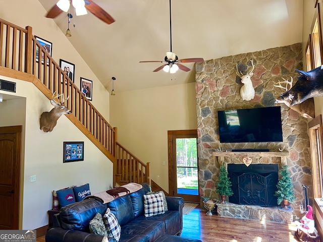 54 Lodge Ground Ln, Hawkinsville, GA 31036 - living room with high vaulted ceiling, stairs, a stone fireplace, ceiling fan, and visible vents
