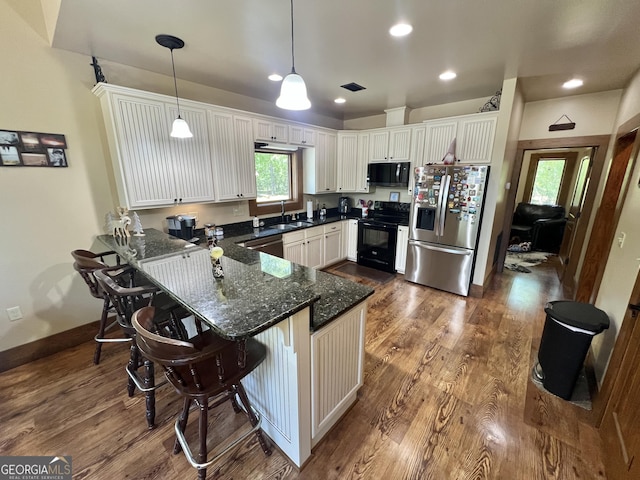 54 Lodge Ground Ln, Hawkinsville, GA 31036 - kitchen featuring a peninsula, decorative light fixtures, dark wood-style floors, and black appliances