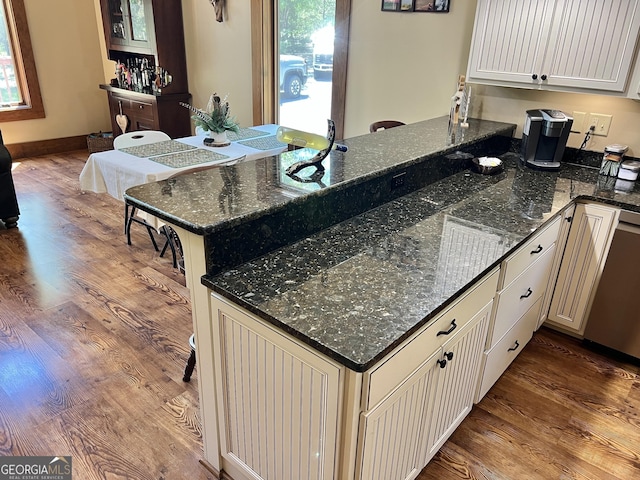 54 Lodge Ground Ln, Hawkinsville, GA 31036 - kitchen featuring a peninsula, dishwasher, wood finished floors, and dark stone countertops