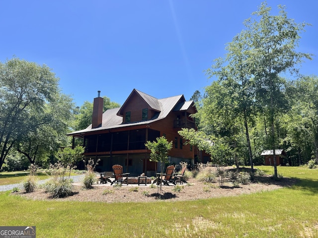 54 Lodge Ground Ln, Hawkinsville, GA 31036 - view of home's exterior featuring a yard, a chimney, and an outdoor fire pit