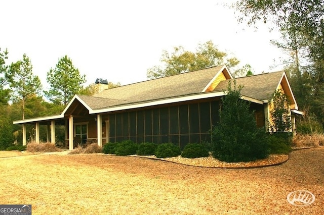 54 Lodge Ground Ln, Hawkinsville, GA 31036 - view of side of property with a sunroom, a shingled roof, and a chimney
