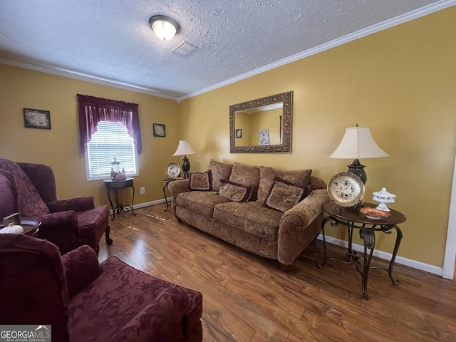 living area with a textured ceiling, visible vents, baseboards, wood finished floors, and ornamental molding
