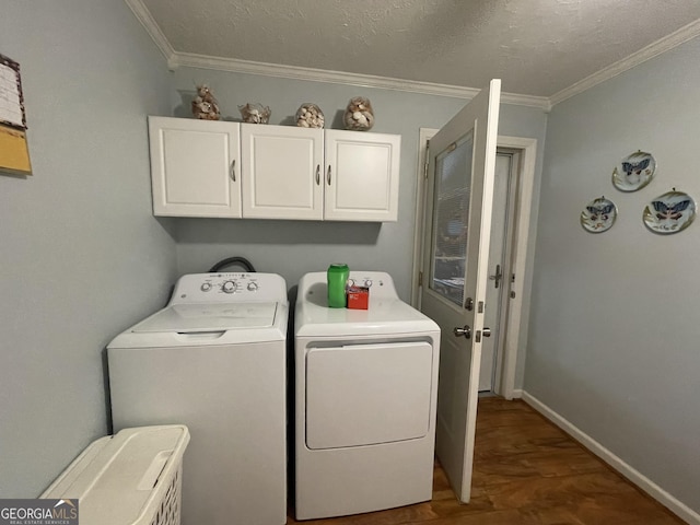 laundry room featuring crown molding, wood finished floors, cabinet space, washing machine and dryer, and baseboards