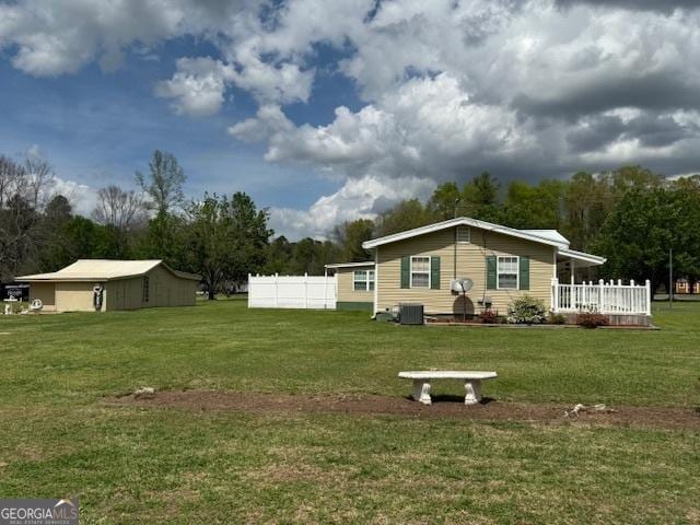 view of yard with central AC unit and fence