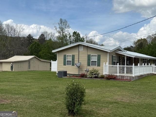 exterior space with covered porch, a yard, and central air condition unit