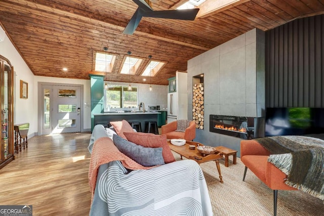 361 Rising Star Rd Unit 14, Ellijay, GA 30536 - living room featuring a skylight, wooden ceiling, ceiling fan, light wood-style floors, and a tile fireplace