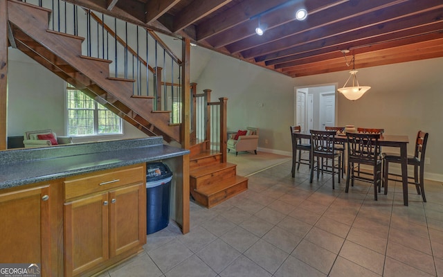 500 Old Mize Rd, Toccoa, GA 30577 - interior space with dark countertops, brown cabinetry, light tile patterned flooring, pendant lighting, and beam ceiling
