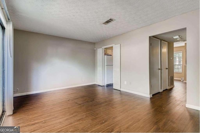 6593 Sleepy Hollow Ln, Morrow, GA 30260 - interior space featuring a textured ceiling, wood finished floors, baseboards, visible vents, and freestanding refrigerator