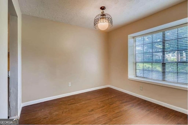 6593 Sleepy Hollow Ln, Morrow, GA 30260 - empty room featuring dark wood finished floors, a textured ceiling, and baseboards