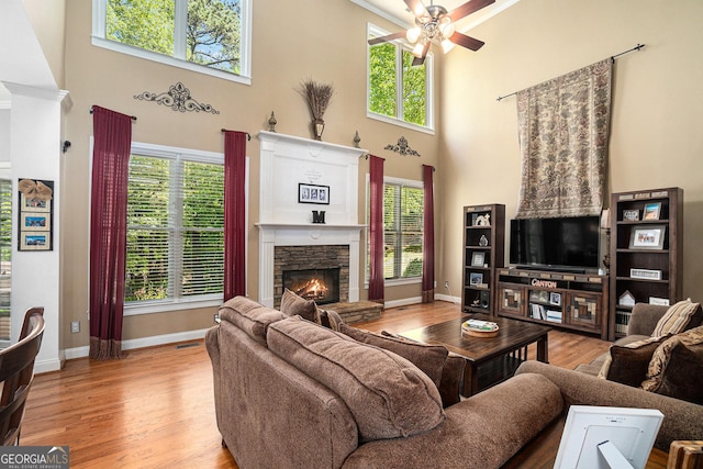 629 Gold Valley Pass, Canton, GA 30114 - living room featuring a fireplace, ceiling fan, baseboards, and a towering ceiling