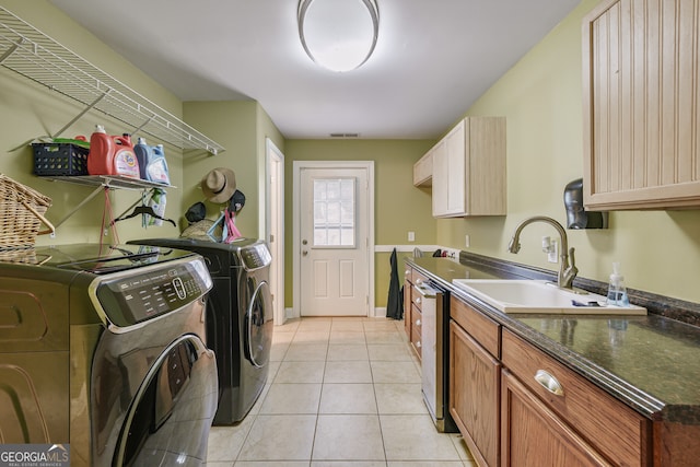 clothes washing area with washing machine and dryer, light tile patterned floors, and baseboards