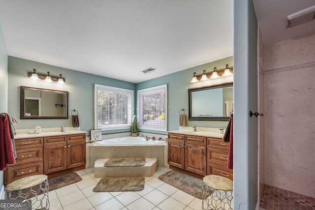 full bathroom with two vanities, a bath, and tile patterned flooring