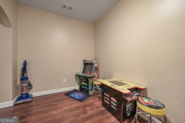 playroom featuring wood finished floors, arched walkways, and baseboards