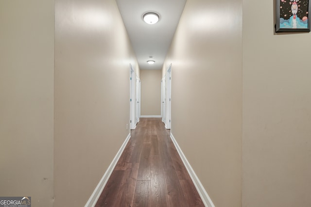 hall with dark wood-style floors and baseboards