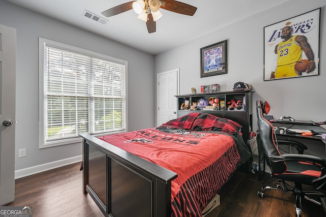 bedroom with wood finished floors, baseboards, an office area, and a ceiling fan