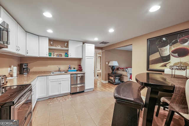 kitchen featuring stainless steel appliances, a sink, white cabinetry, recessed lighting, and open shelves