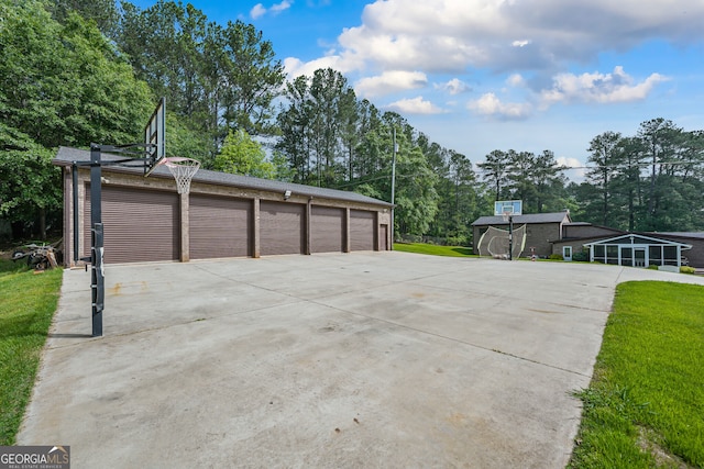 garage with concrete driveway and view of scattered trees