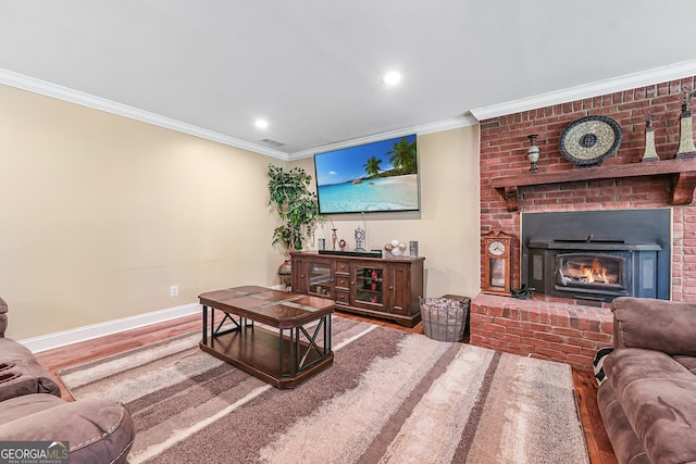 living area with wood finished floors, baseboards, ornamental molding, a brick fireplace, and recessed lighting