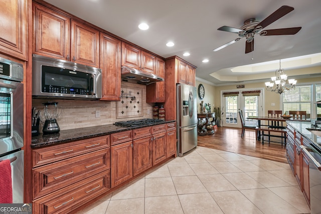 kitchen featuring stainless steel appliances, under cabinet range hood, ceiling fan, brown cabinetry, and recessed lighting