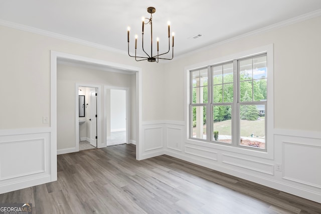 130 Rudders Xing, Newnan, GA 30263 - unfurnished dining area featuring a chandelier, wood finished floors, ornamental molding, and wainscoting