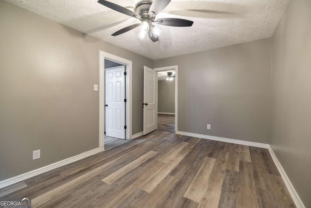 451 Woodlawn Dr, Crawford, GA 30630 - unfurnished bedroom with baseboards, wood finished floors, a textured ceiling, and ceiling fan