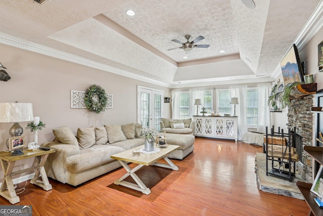 122 Eagle View Dr, Monticello, GA 31064 - living room featuring a raised ceiling, a ceiling fan, crown molding, wood finished floors, and a fireplace