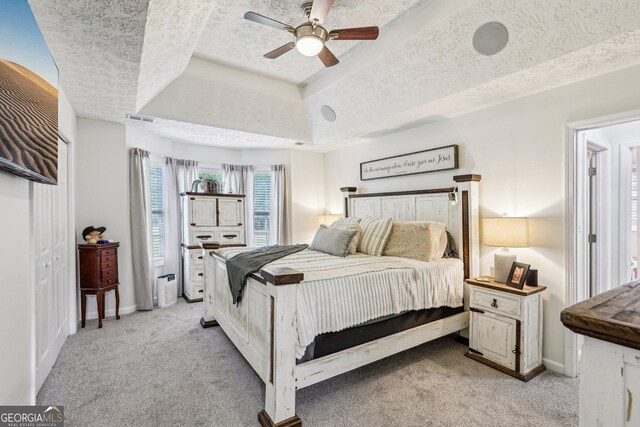 122 Eagle View Dr, Monticello, GA 31064 - bedroom featuring a tray ceiling, light colored carpet, a textured ceiling, baseboards, and ceiling fan