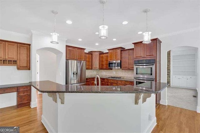 kitchen featuring appliances with stainless steel finishes, tasteful backsplash, and light wood-type flooring