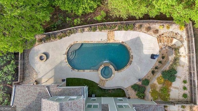 pool at dusk featuring fence, a patio, a fenced in pool, and an in ground hot tub