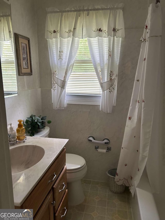 bathroom with toilet, vanity, and tile patterned floors
