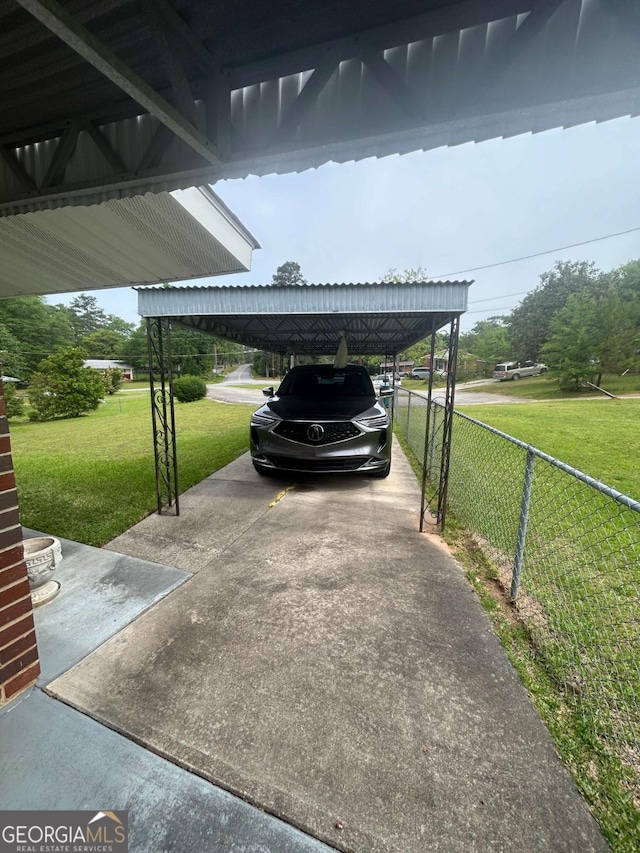 view of vehicle parking featuring concrete driveway and fence