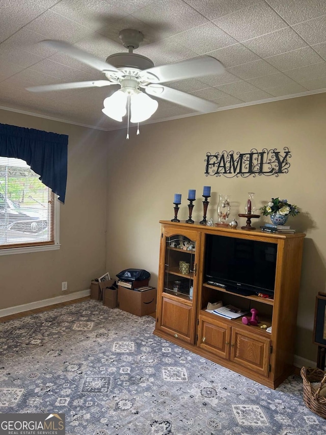 carpeted living room featuring a ceiling fan and ornamental molding