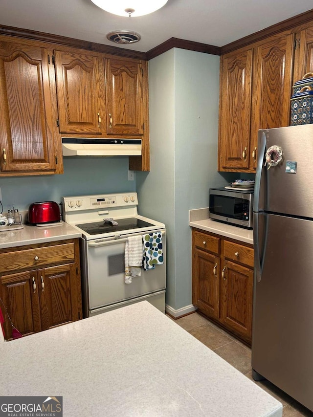 kitchen featuring light countertops, brown cabinetry, appliances with stainless steel finishes, and under cabinet range hood