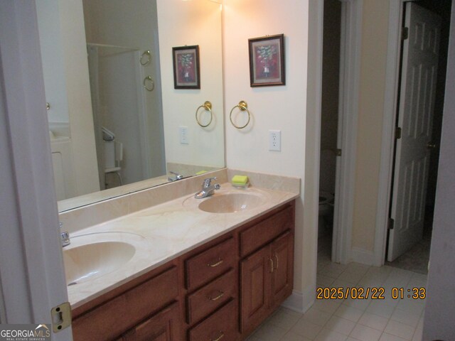 full bathroom with tile patterned flooring, walk in shower, a sink, and double vanity