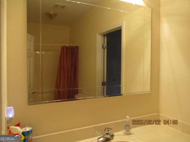 bathroom featuring vanity and curtained shower