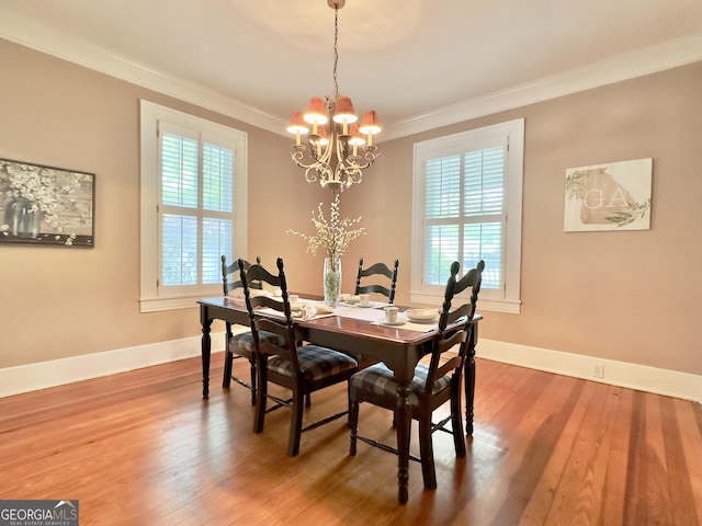 dining room featuring ornamental molding, wood finished floors, and a notable chandelier