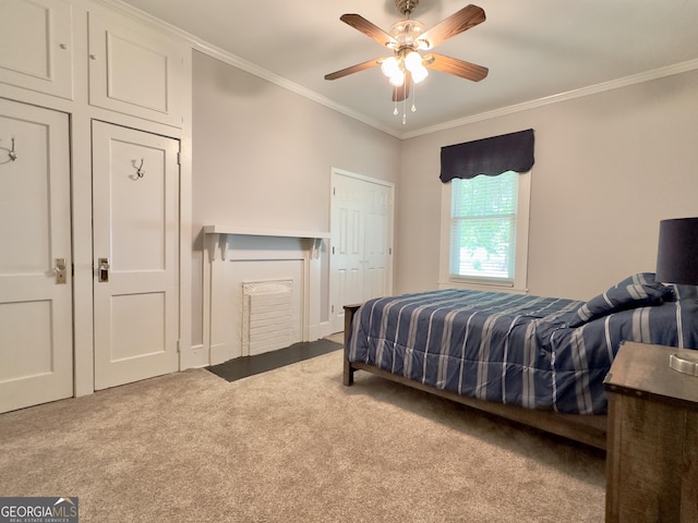 carpeted bedroom with ornamental molding and ceiling fan