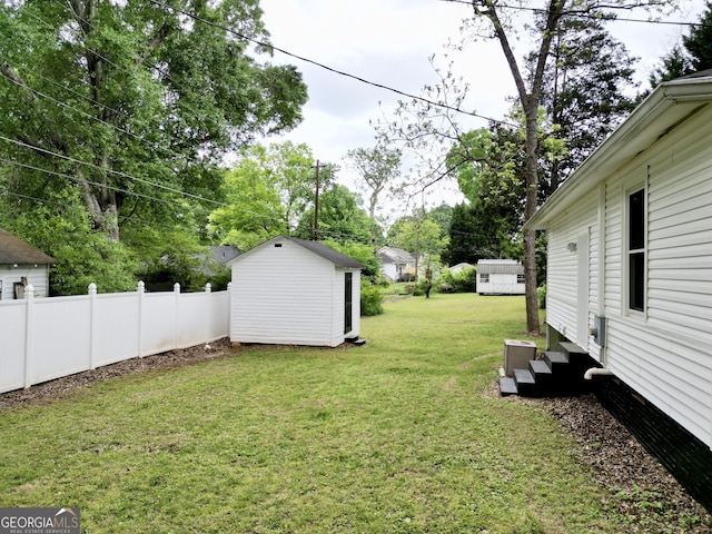 view of yard featuring entry steps, fence, an outbuilding, and a storage shed