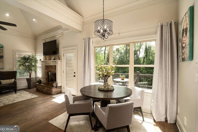 175 Tillman Ln, Athens, GA 30606 - dining space with wood finished floors, vaulted ceiling, a chandelier, a stone fireplace, and crown molding