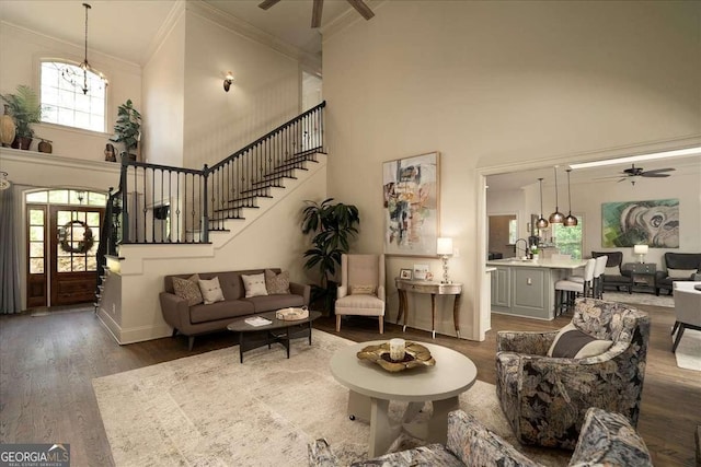 175 Tillman Ln, Athens, GA 30606 - living room featuring a ceiling fan, a towering ceiling, crown molding, dark wood-style floors, and stairs