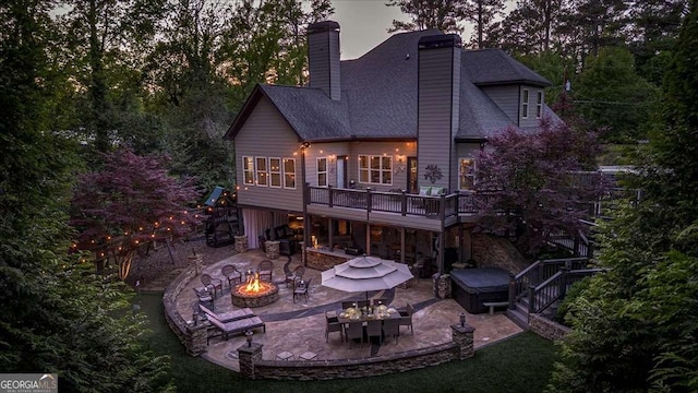 175 Tillman Ln, Athens, GA 30606 - rear view of property featuring a fire pit, a hot tub, a patio area, a wooden deck, and a chimney