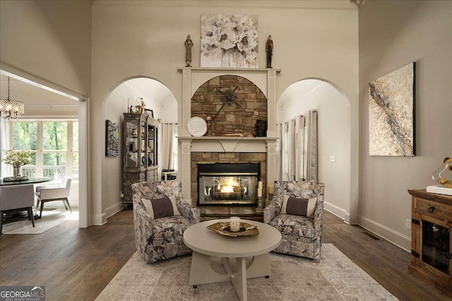 175 Tillman Ln, Athens, GA 30606 - living room with wood finished floors, baseboards, a fireplace, a high ceiling, and arched walkways