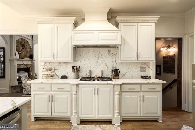 175 Tillman Ln, Athens, GA 30606 - kitchen with appliances with stainless steel finishes, custom exhaust hood, backsplash, light wood-style floors, and light stone counters