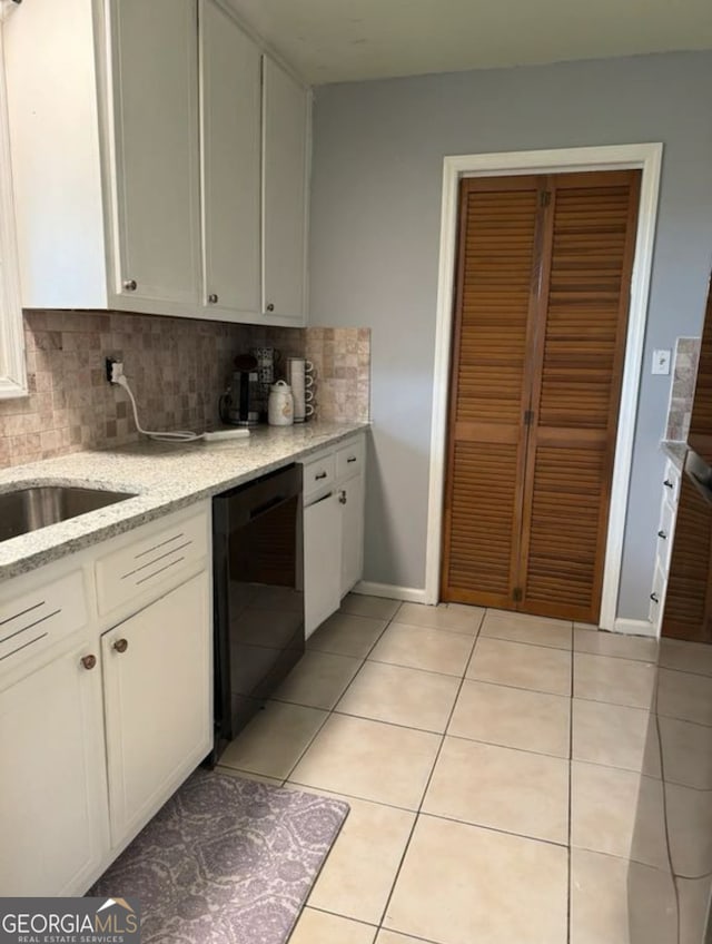 2461 Mcalpin Ter, East Point, GA 30344 - kitchen with dishwasher, decorative backsplash, white cabinets, light tile patterned floors, and light stone counters